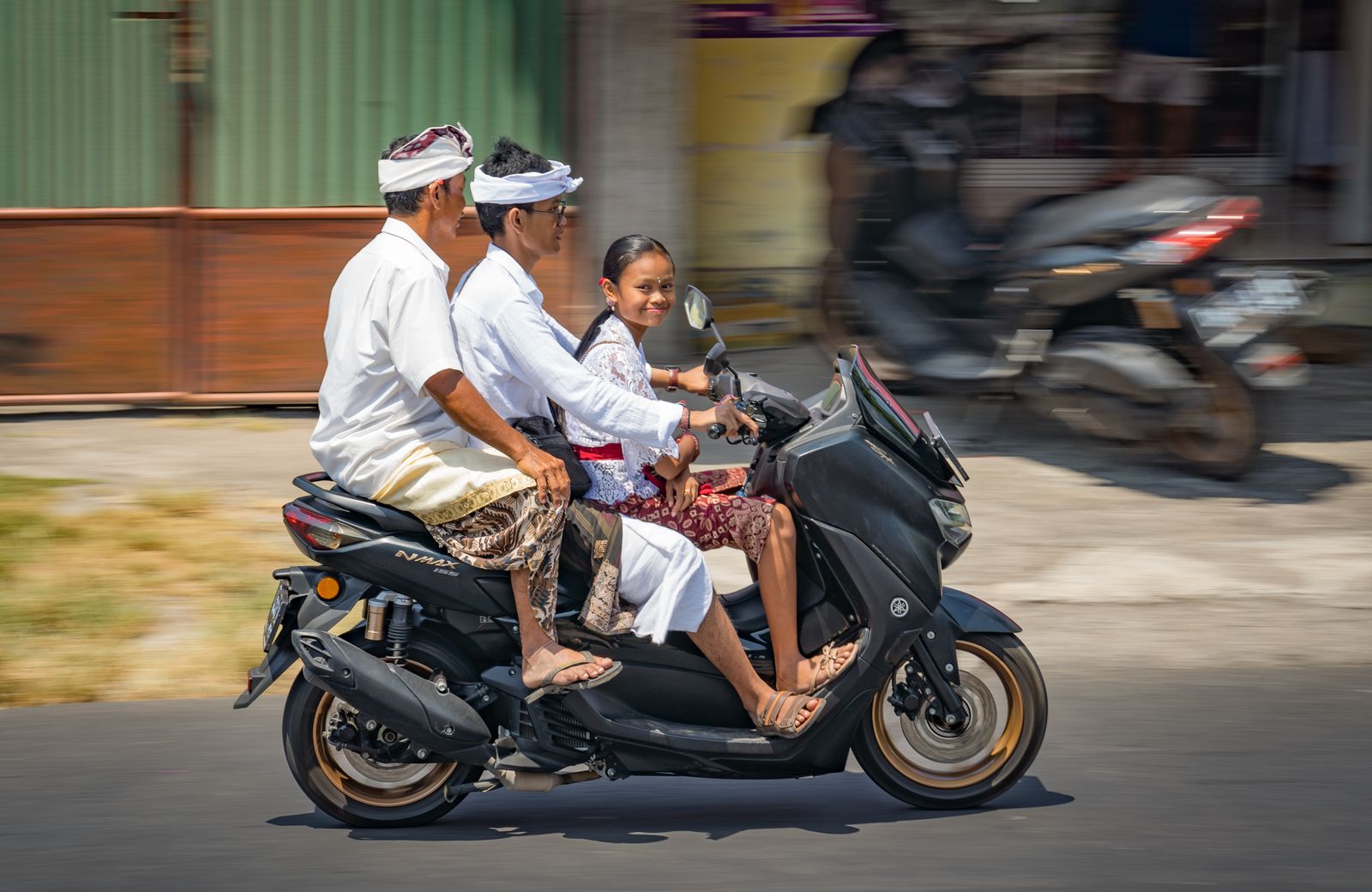 Balinese family riding a scooter on a local street