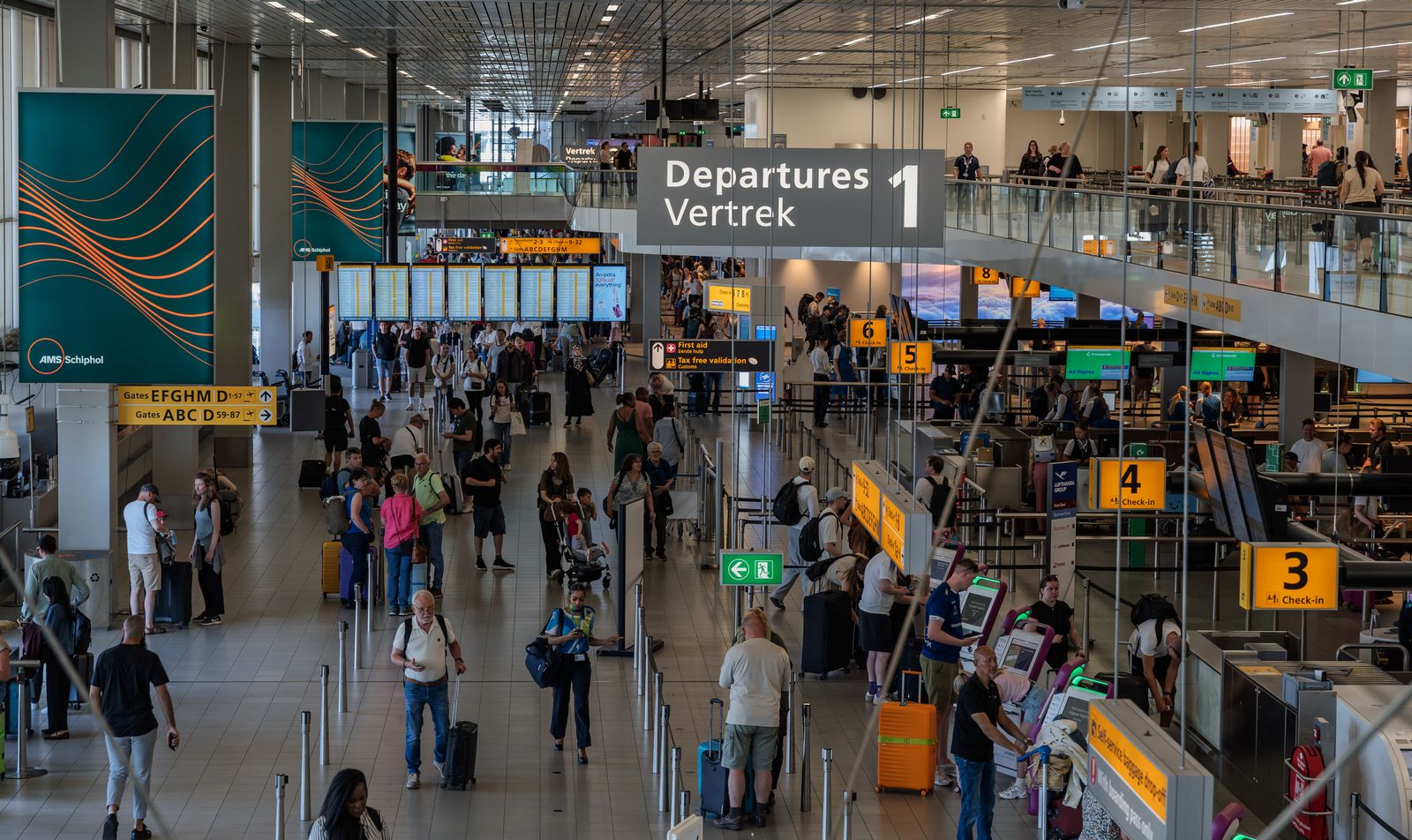 Travellers waiting in a busy airport departure hall